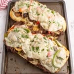 overhead shot of philly cheesesteak bread on a baking sheet.