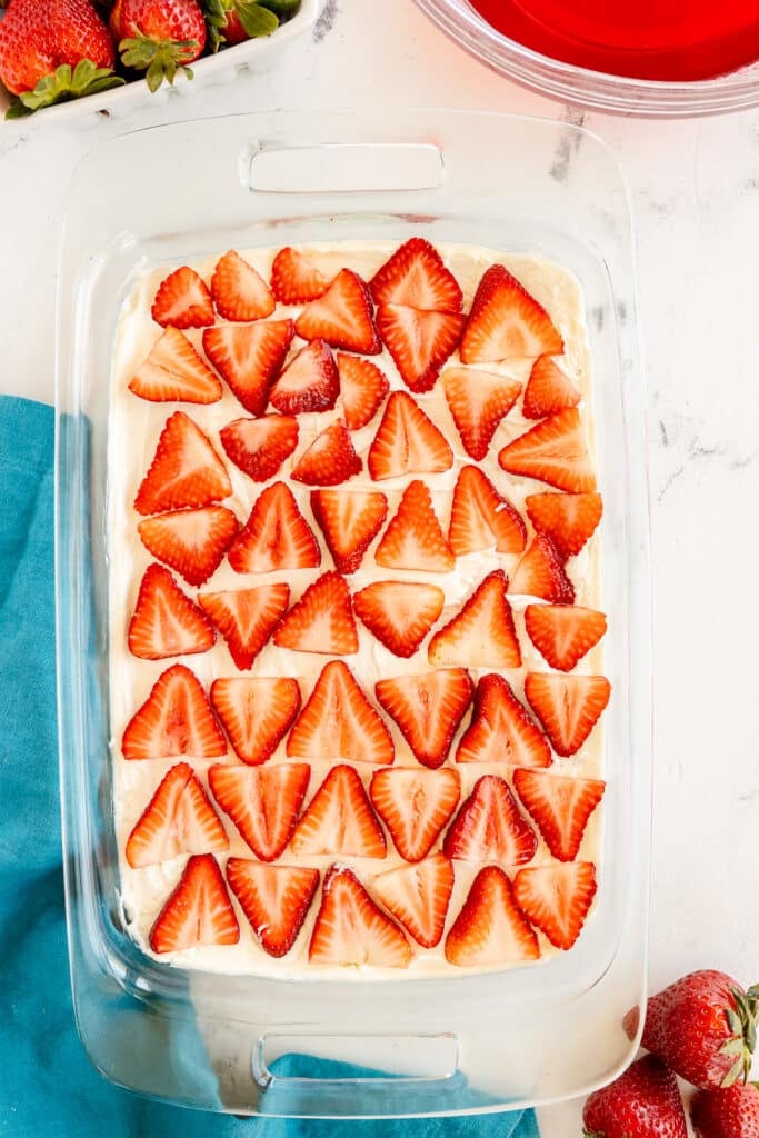 a layer of sliced strawberries in a baking dish.