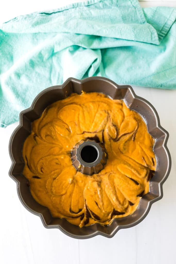 swirled chocolate and pumpkin cake batter in a bundt pan.