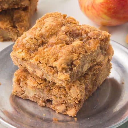 a stack of apple blondies with peanut butter chips on a silver plate.