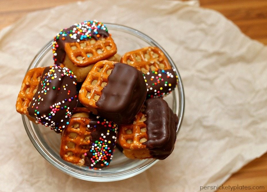 glass bowl filled with chocolate dipped peanut butter pretzel bites