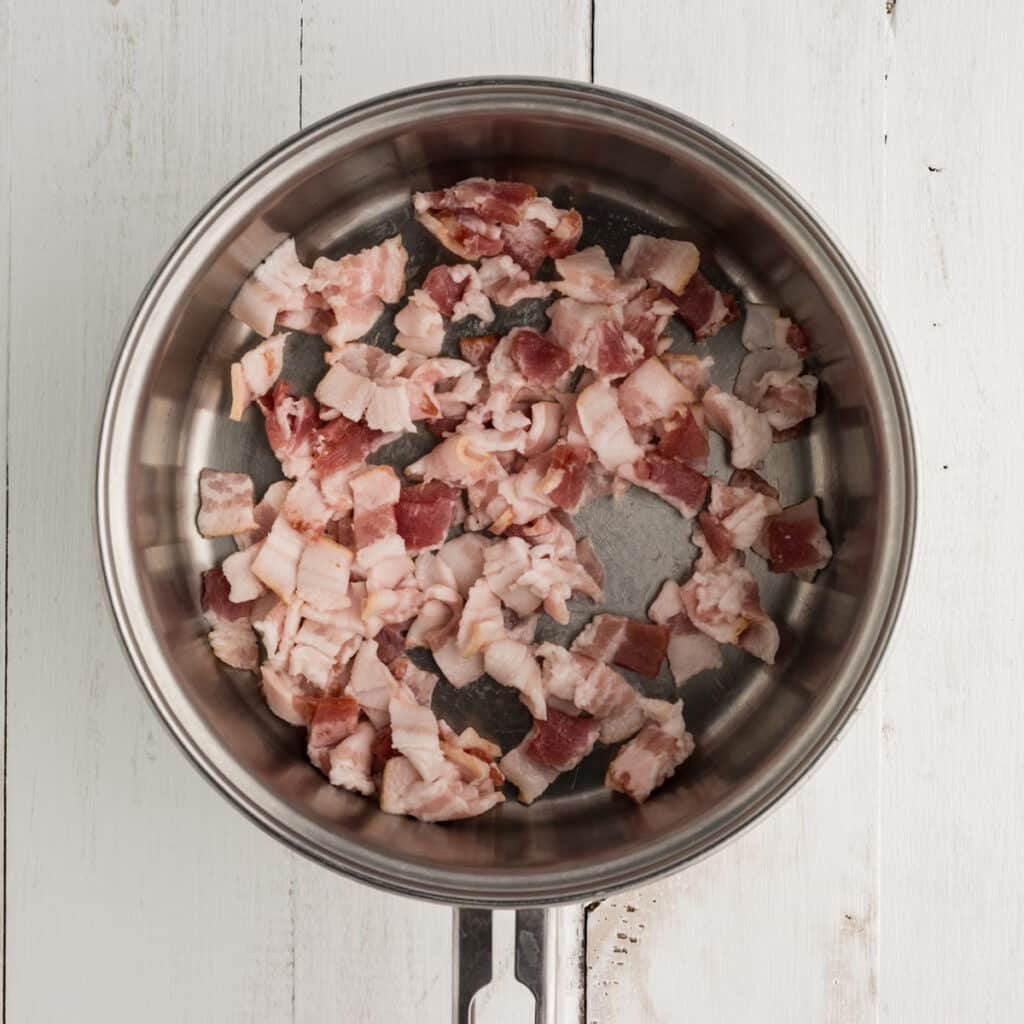 overhead shot of bacon pieces in a saucepan.