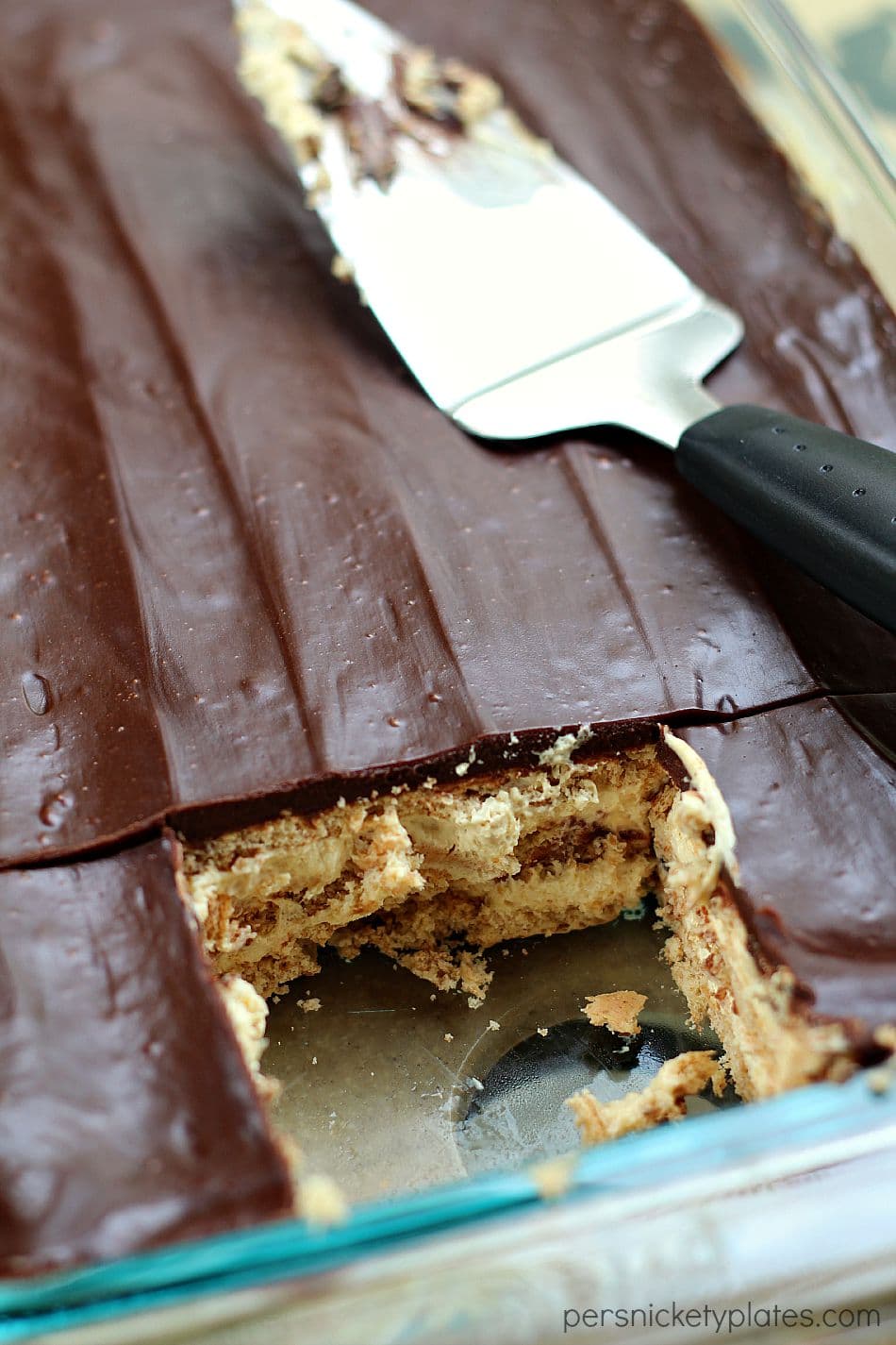 pan of chocolate peanut butter eclair dessert in baking dish with serving spoon 