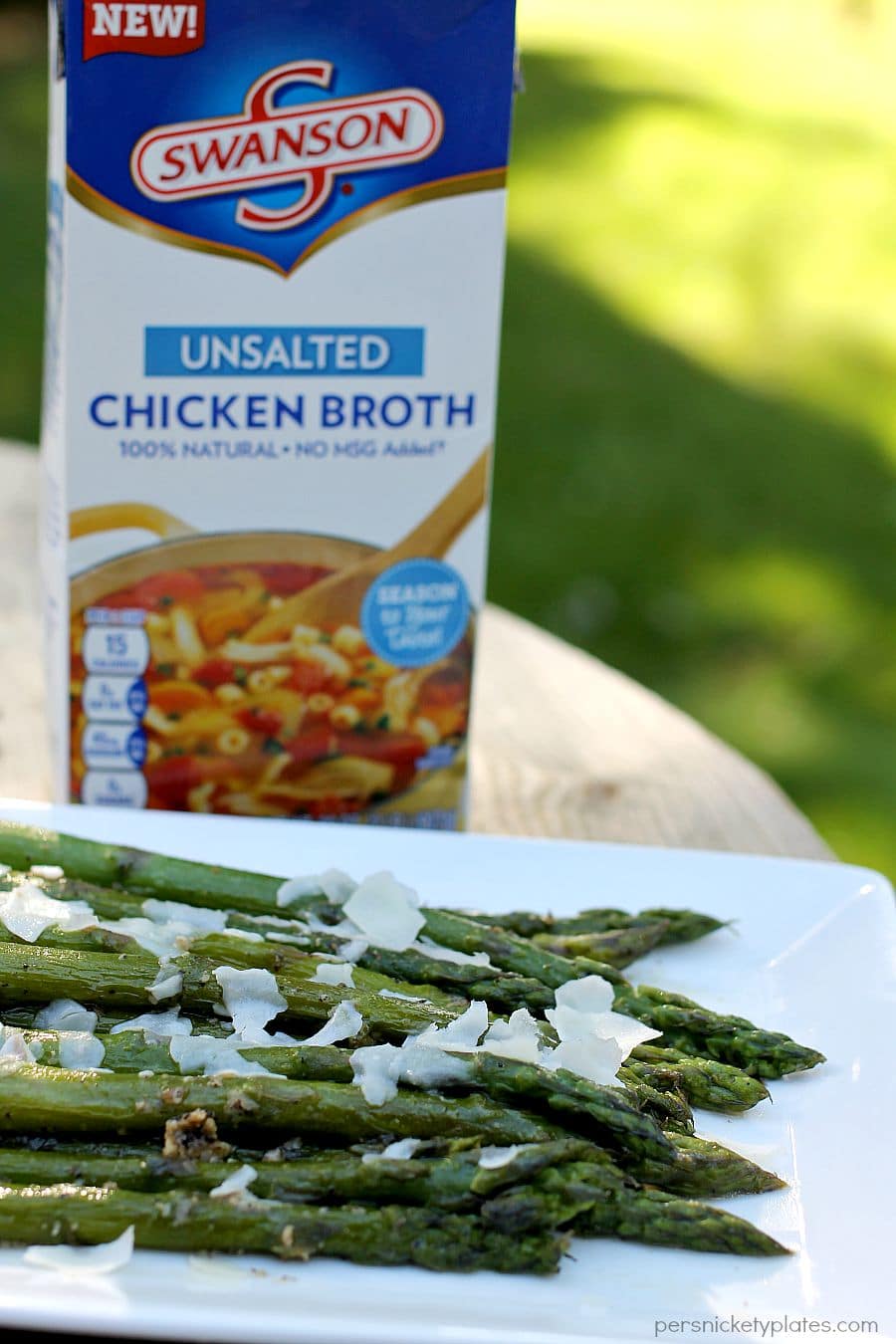 sauteed asparagus on white platter in front of swanson chicken broth carton
