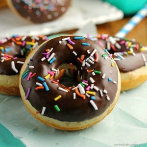 Chocolate Glazed Baked Cake Donuts covered in sprinkles. Homemade donuts are probably easier to make than you think and you can save a trip to the donut shop! | www.persnicketyplates.com