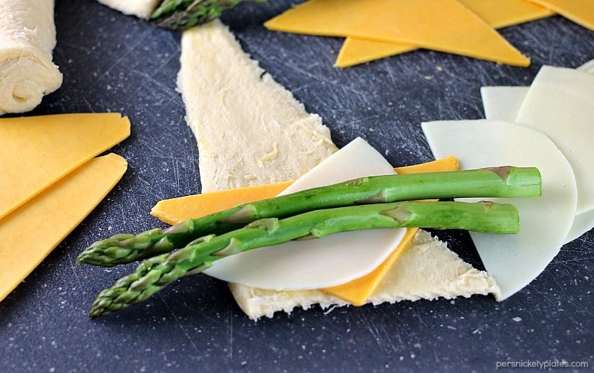 cheesy asparagus puffs prepped on a cutting board