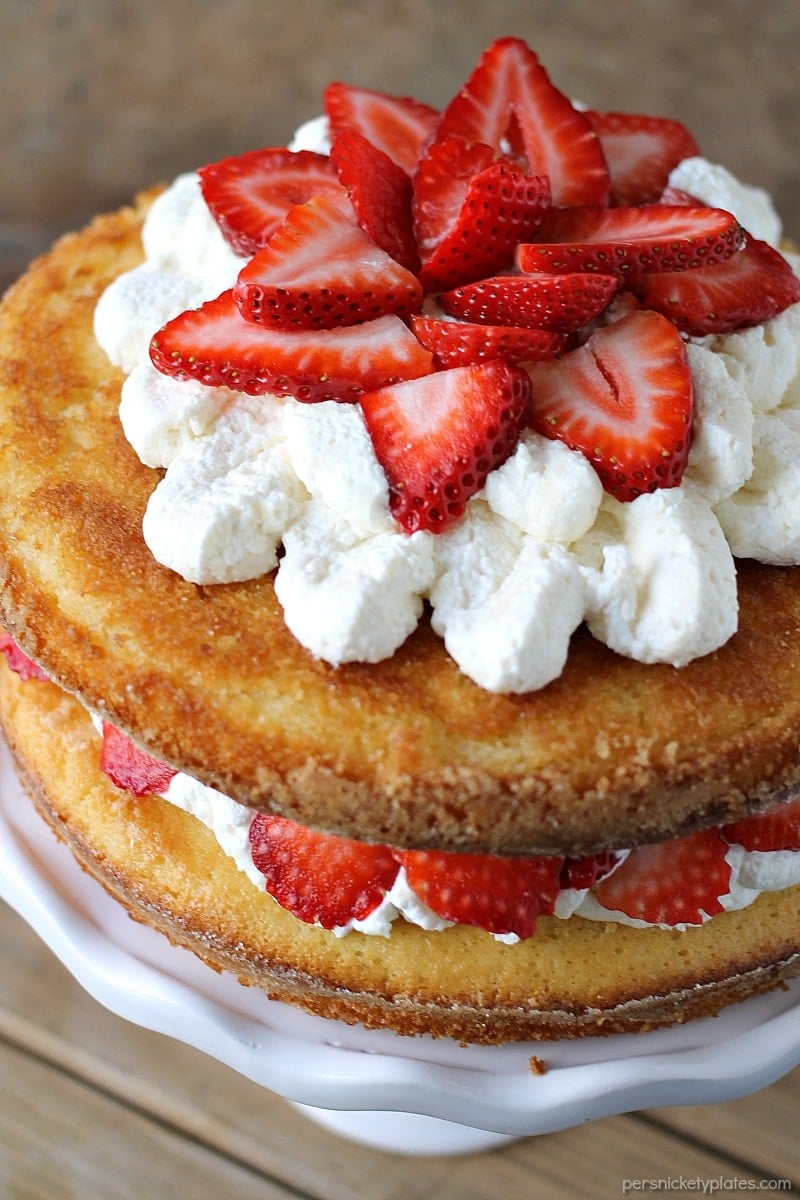 Strawberry Shortcake Cake is a rustic vanilla layer cake filled with a whipped cream cheese frosting and fresh strawberries. Easy, impressive, and SO good! | www.persnicketyplates.com