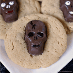 Peanut Butter Butterfinger Skull Cookies start with a soft and chewy from scratch peanut butter cookie then are topped with a spooky, decorated Butterfinger Peanut Butter Skull Cup. Perfect for any Halloween party! | www.persnicketyplates.com