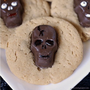 Peanut Butter Butterfinger Skull Cookies start with a soft and chewy from scratch peanut butter cookie then are topped with a spooky, decorated Butterfinger Peanut Butter Skull Cup. Perfect for any Halloween party! | www.persnicketyplates.com