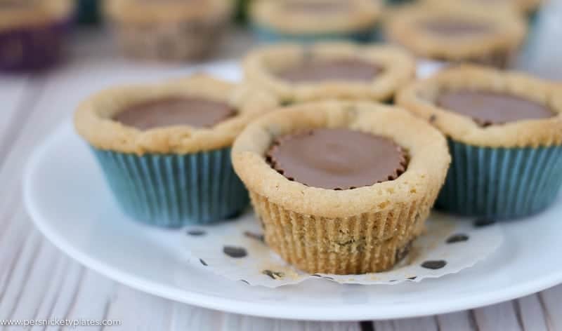 Chocolate Chip Peanut Butter Cookie Cups are only two ingredients and are ready in just 20 minutes. Perfect for a last minute bake sale, class treat, or craving! | www.persnicketyplates.com #easydessert #cookie #cookiecups #semihomemade #dessert four cookie cups on a white plate