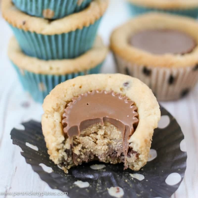 Chocolate Chip Peanut Butter Cookie Cups are only two ingredients and are ready in just 20 minutes. Perfect for a last minute bake sale, class treat, or craving! | www.persnicketyplates.com #easydessert #cookie #cookiecups #semihomemade #dessert chocolate chip peanut butter cookie cup with a bite taken out of it