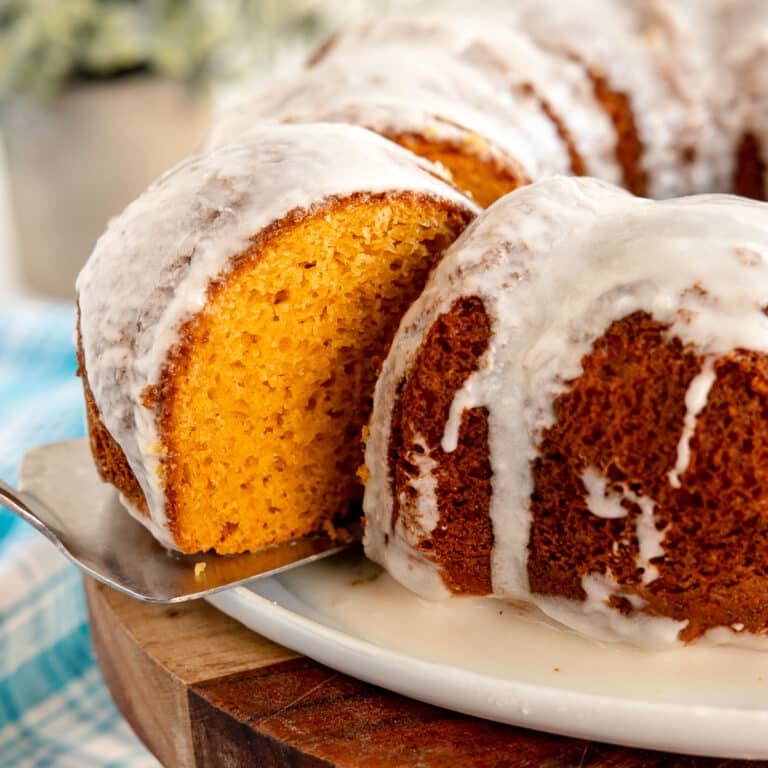 slice of glazed butterscotch bundt cake lifting from a platter.