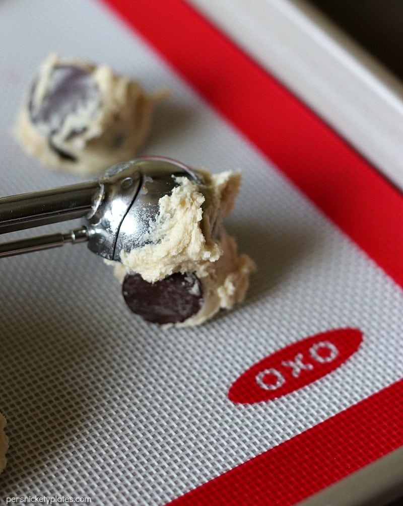 closeup of cookie scoop portioning out Salted Chocolate Chip cookies