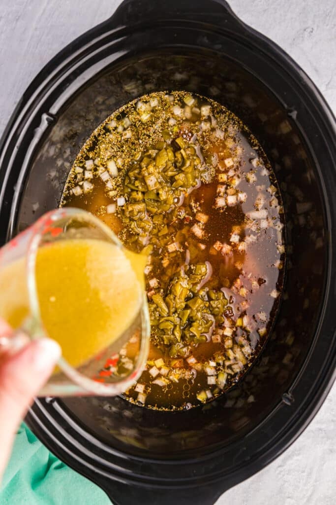sauce pouring into a slow cooker.