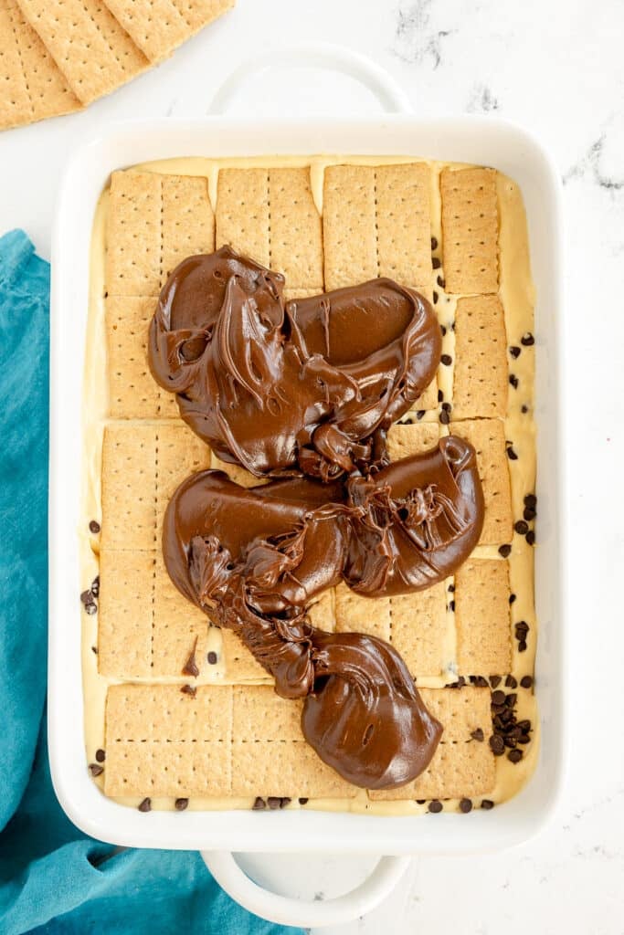 chocolate frosting on graham crackers in a baking dish.