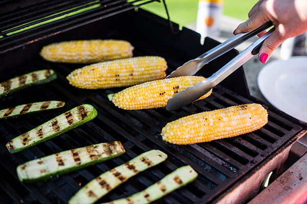 corn being grilled with zucchini