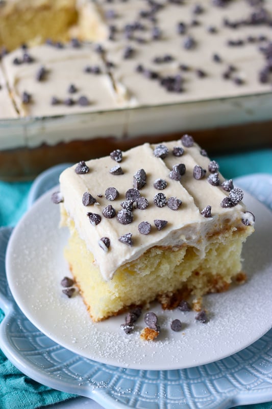 slice of cannoli poke cake sprinkled with powder sugar