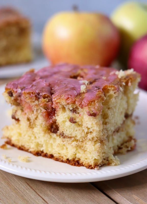 honey bun cake slice with pink frosting on white plate