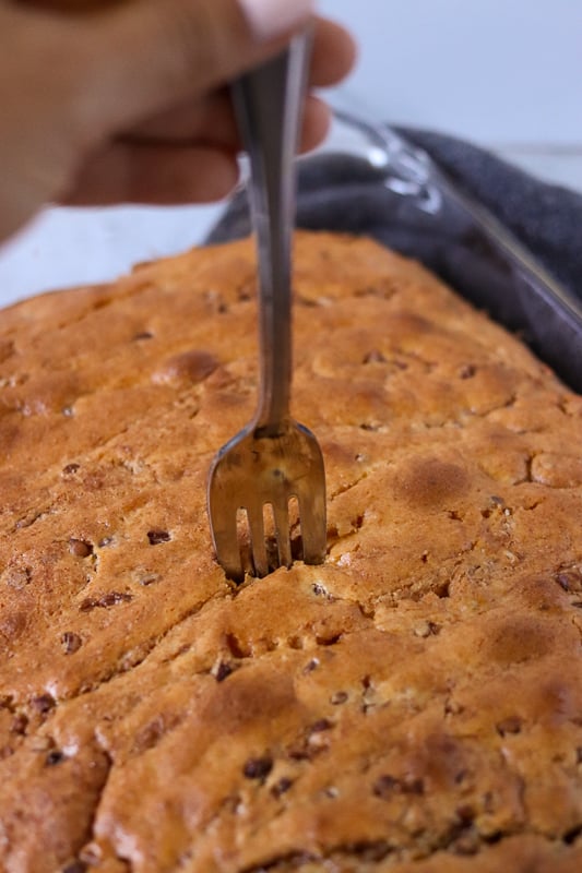 fork poking holes into a cake