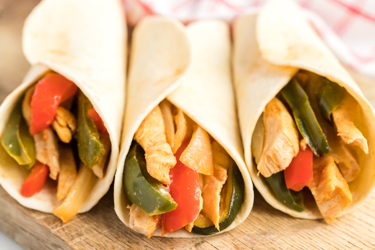 three chicken fajitas in tortillas