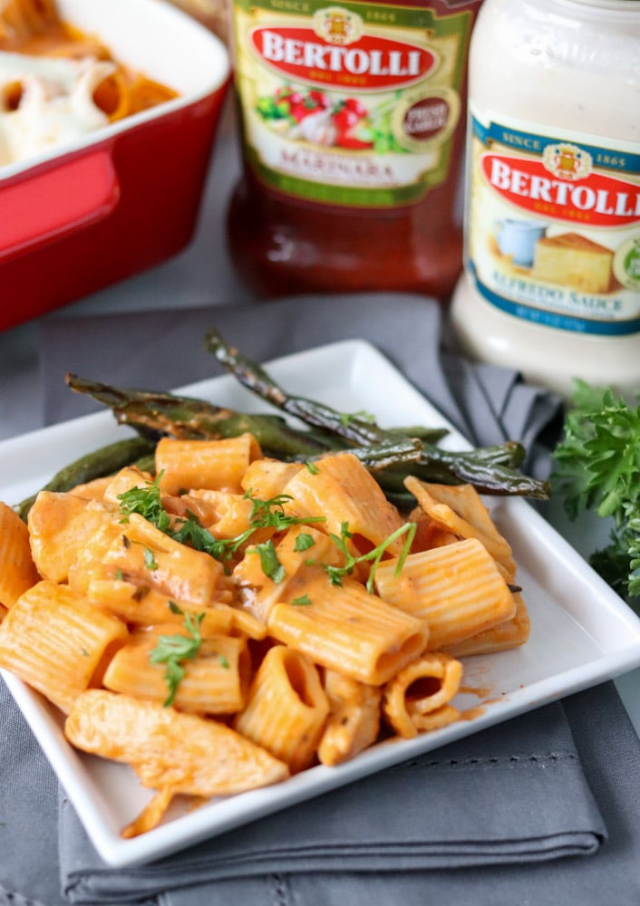 rosa pasta on a white plate with green beans