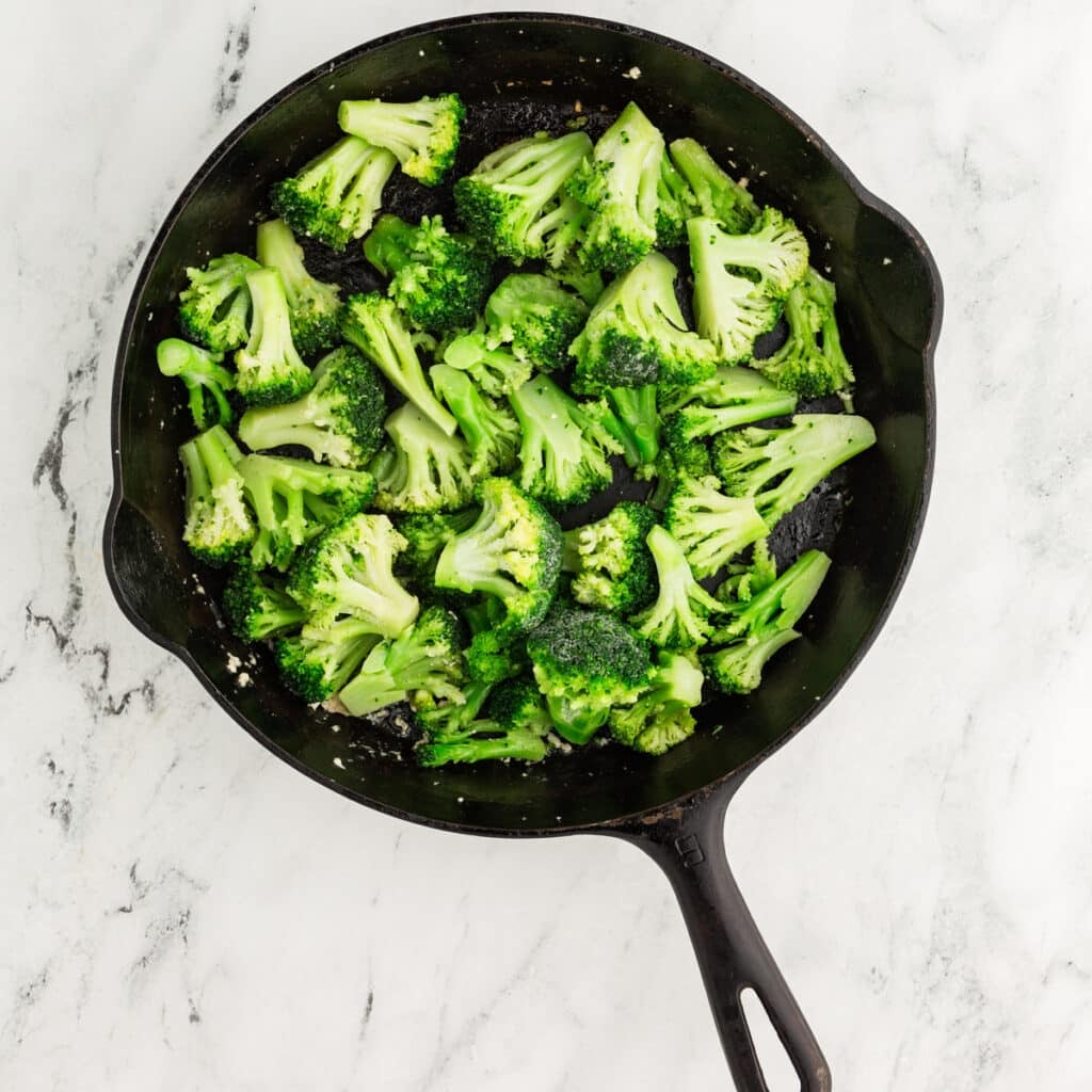 overhead shot of broccoli in a cast iron skillet.