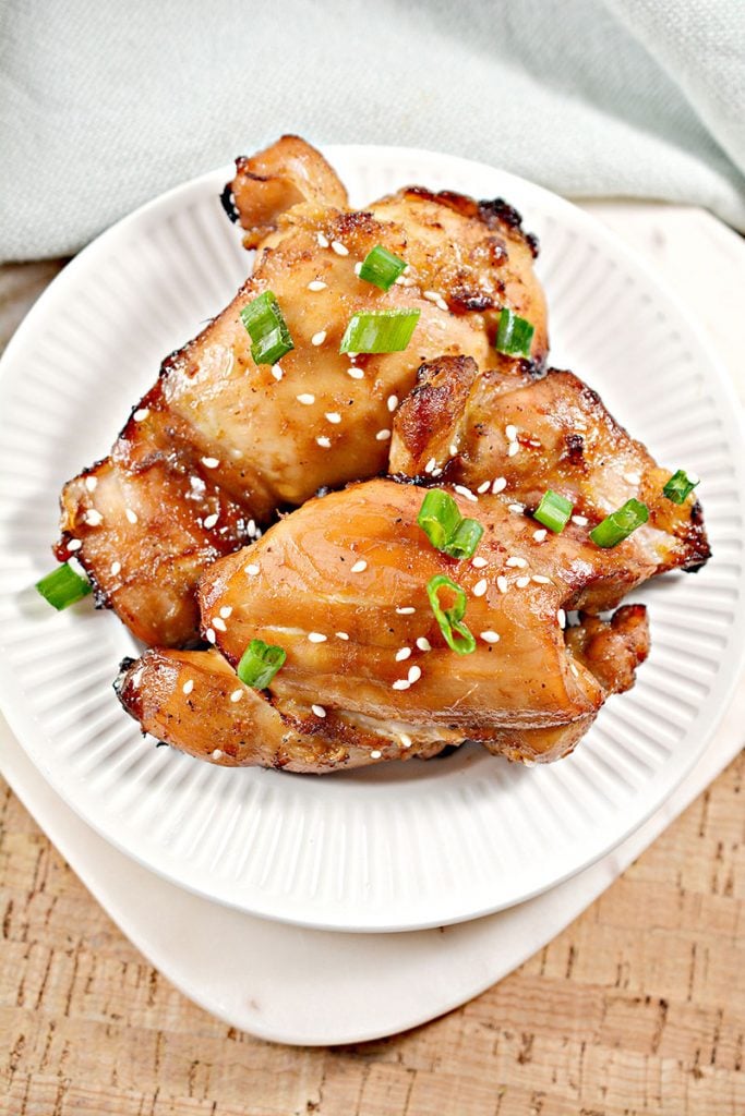 overhead shot of sticky chicken on white plate