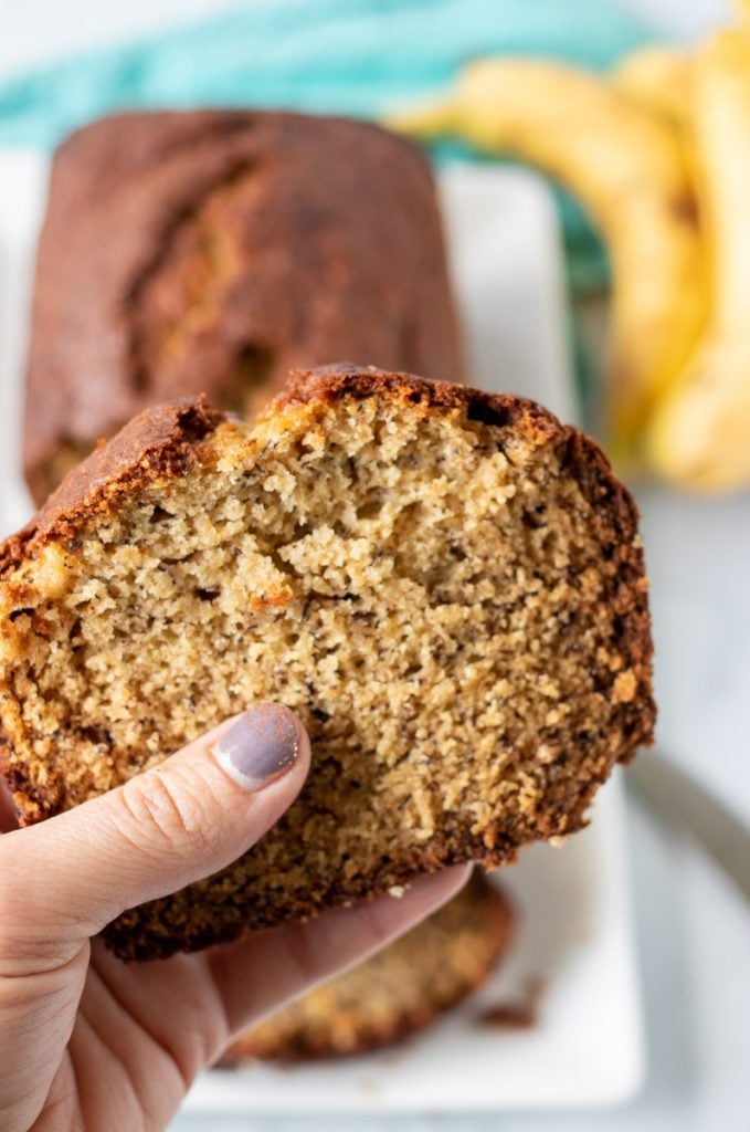 hand holding a slice of banana bread