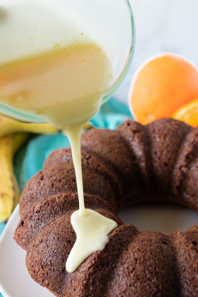 glaze being poured onto a bundt cake
