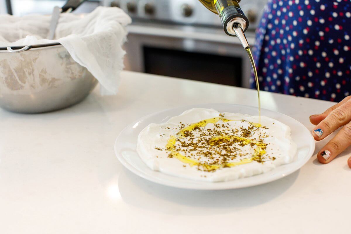 Drizzling labneh with olive oil.