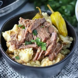 close up on bowl of mississippi pot roast over mashed potatoes