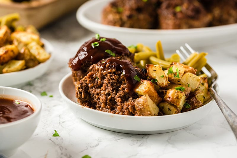 sliced meatloaf muffin on a plate with roasted potatoes