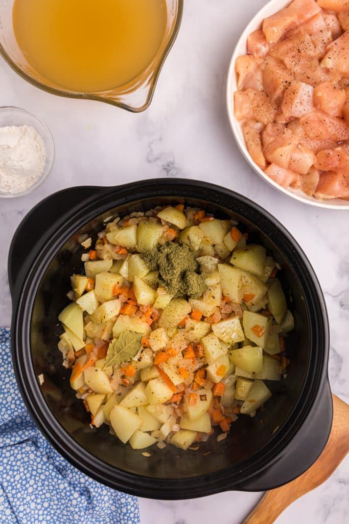 overhead shot of a dutch oven with potatoes, carrots, and onions.