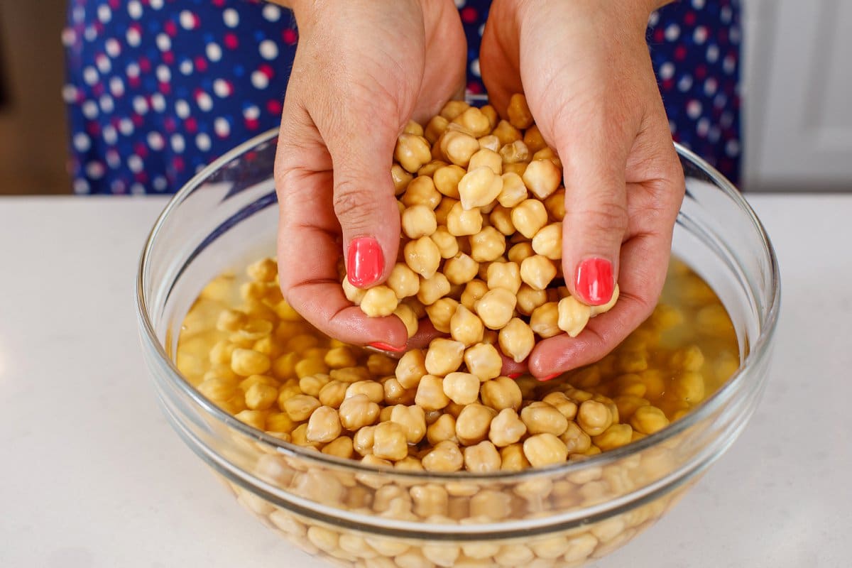 Soaking dried chickpeas in a glass bowl.