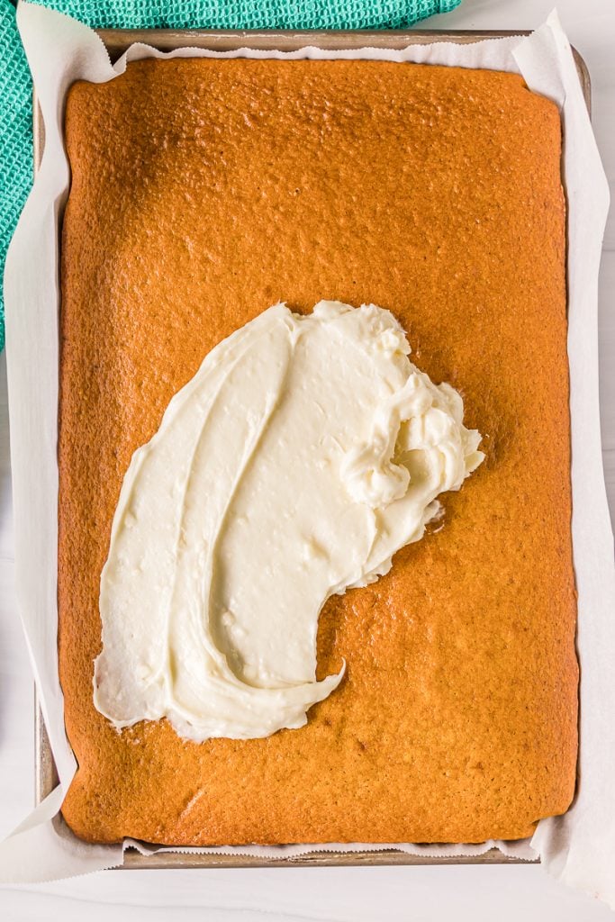 cream cheese frosting being spread onto pumpkin bars