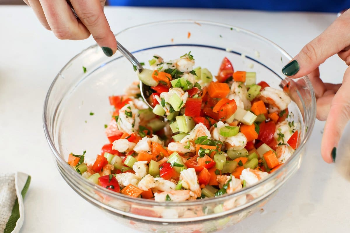 stirring shrimp salad