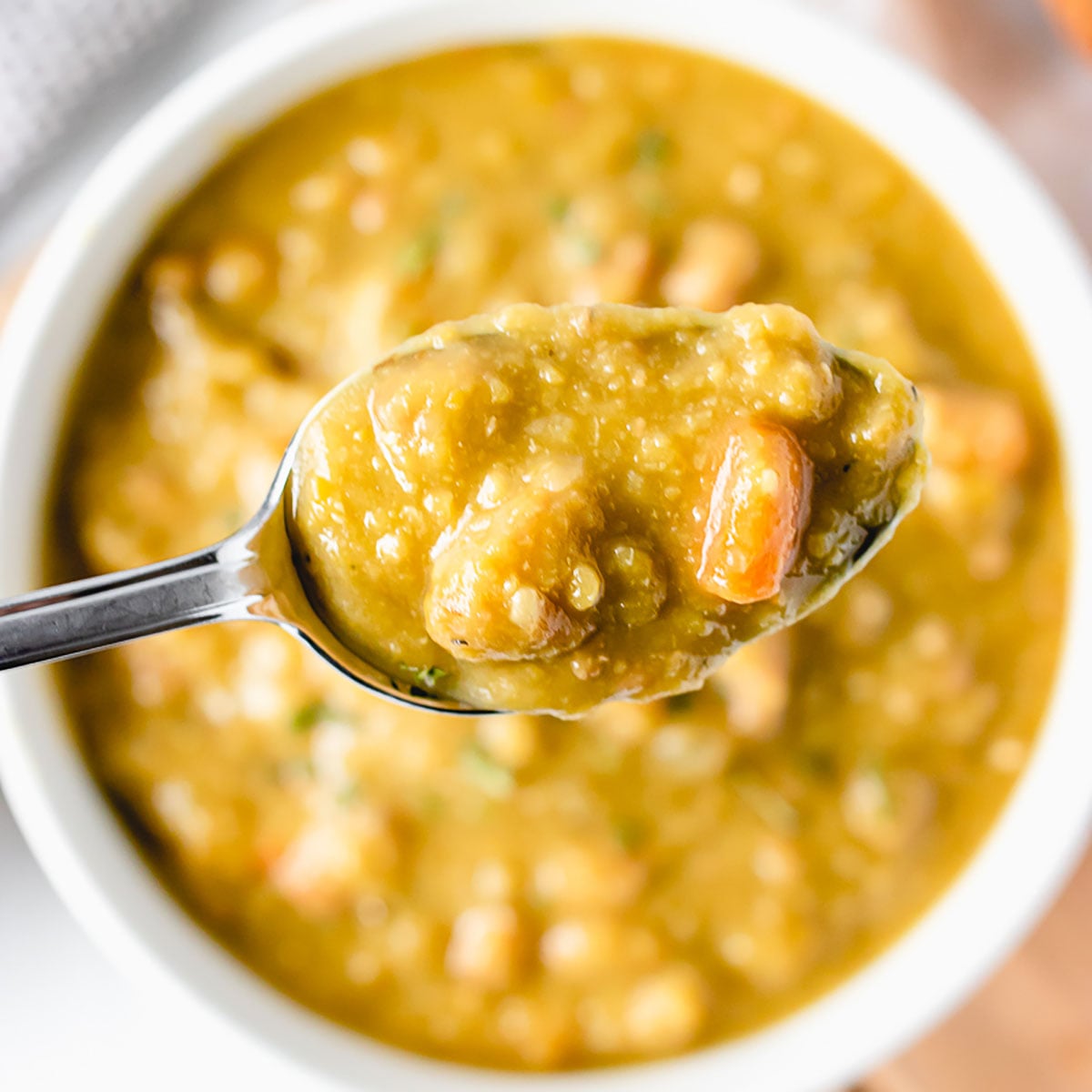 spoon of split pea soup over a bowl