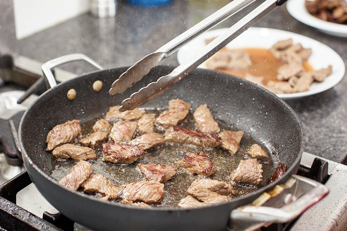 Cooking beef sirloin in a skillet.