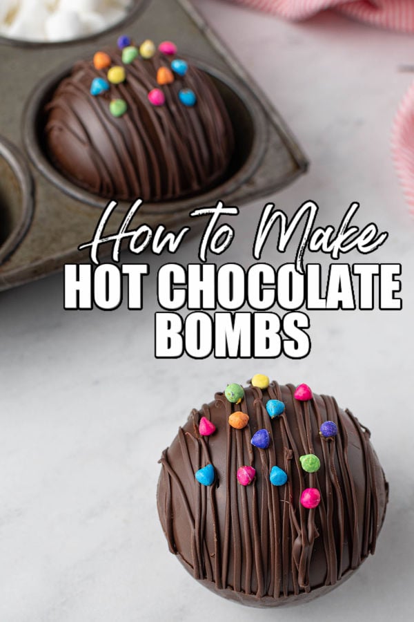 hot cocoa bomb topped with rainbow chips with text reading "how to make hot chocolate bombs"