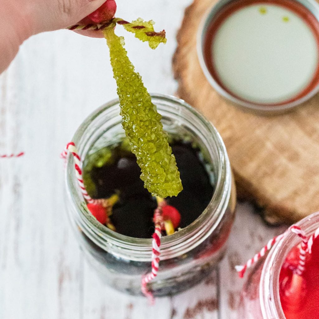 removing rock candy from a mason jar of sugar water