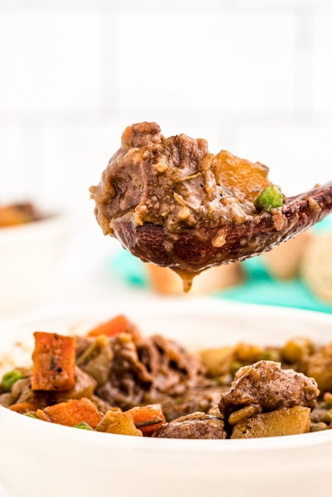 wooden spoon scooping out beef stew