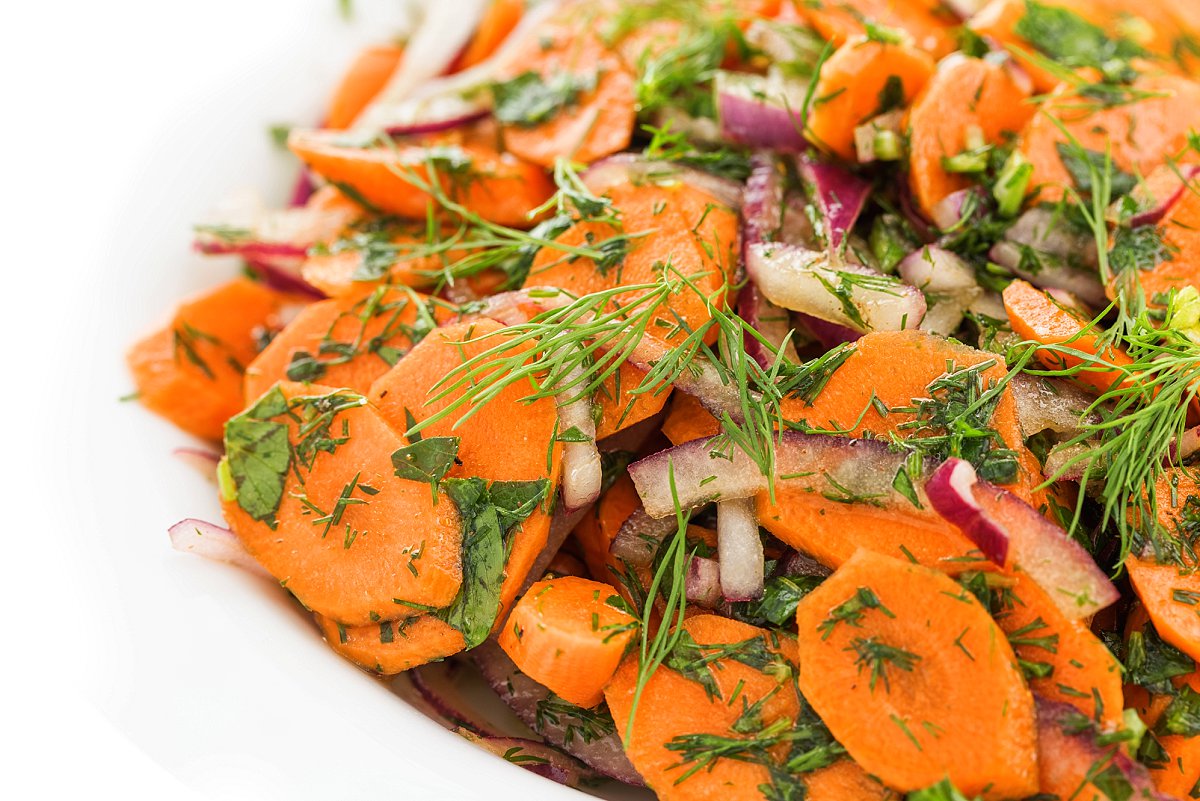 Carrot salad garnished with fresh dill and parsley.
