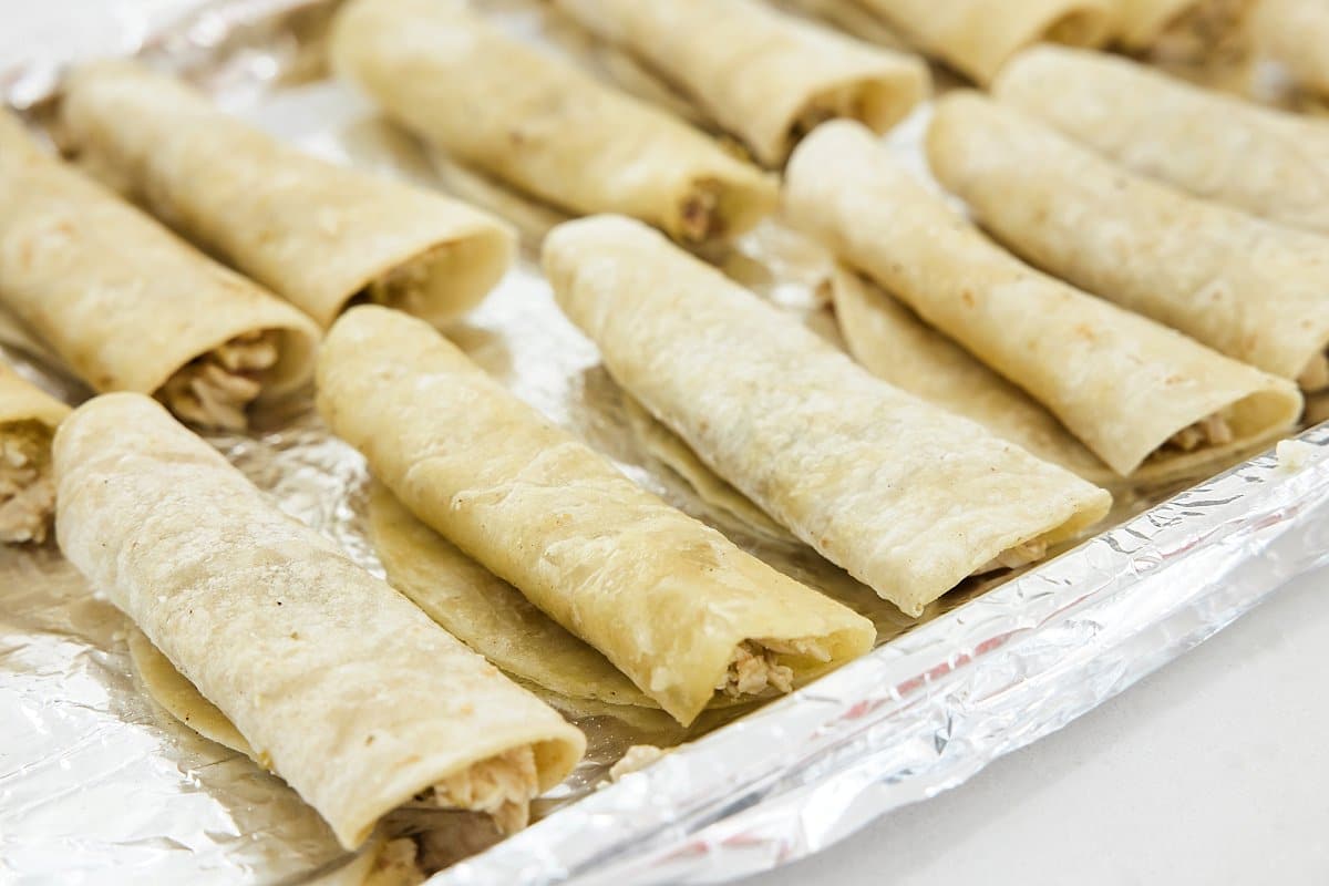 chicken taquitos lined up to bake