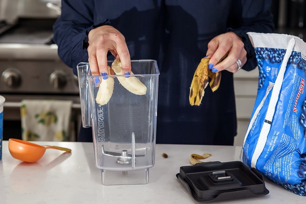 banana being added to a empty blender