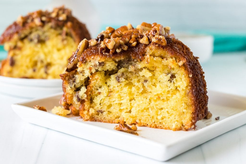 closeup shot of butter pecan cake slice on a white plate