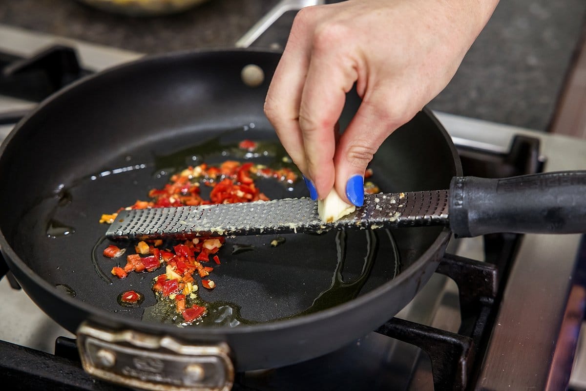 adding garlic and red chili peppers