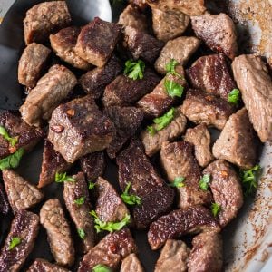 close up of garlic steak bites topped with parsley