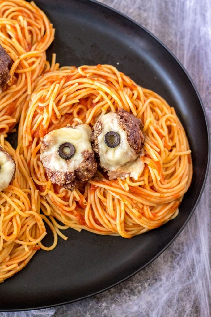 plate of spaghetti topped with spooky eyeball meatballs