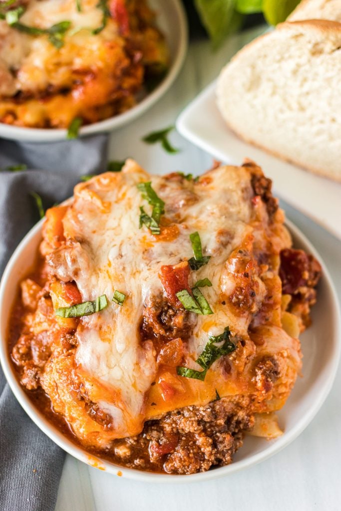 close up shot of slice of lasagna on a white plate