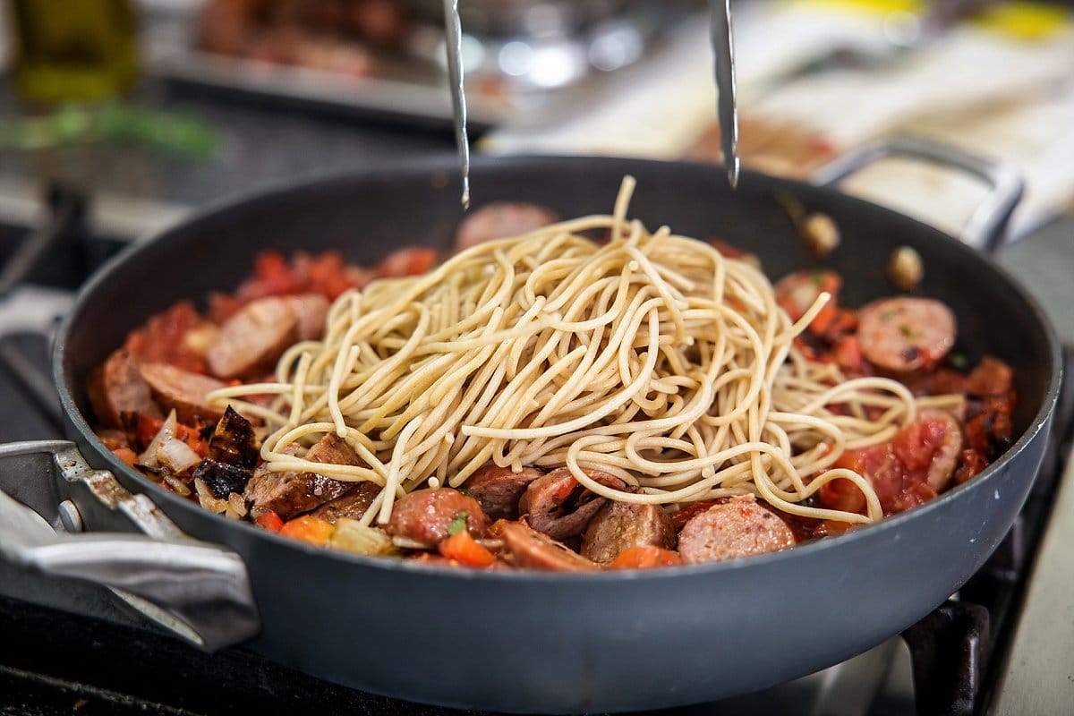 stirring in pasta to a pot